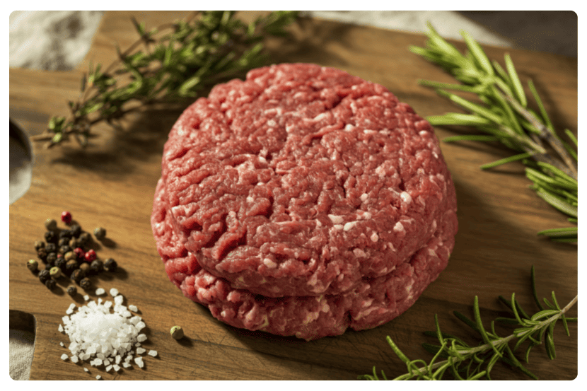 imagem de dois discos de hamburguer cru com temperos em volta - SAIPOS