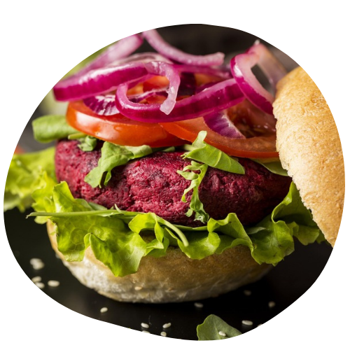 imagem de um hambúrguer vegano com em uma tábua de madeira e elementos visuais do produtos e chamando a atenção para o hambúrguer. o hambúrguer é feito com proteína de soja, alface, tomate e entre outros acompanhamentos.