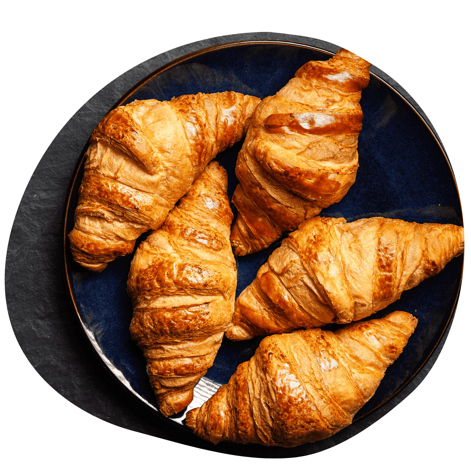 Imagem arredondada de 5 croissants dourados, em cima de um prato azulado em um fundo escuro