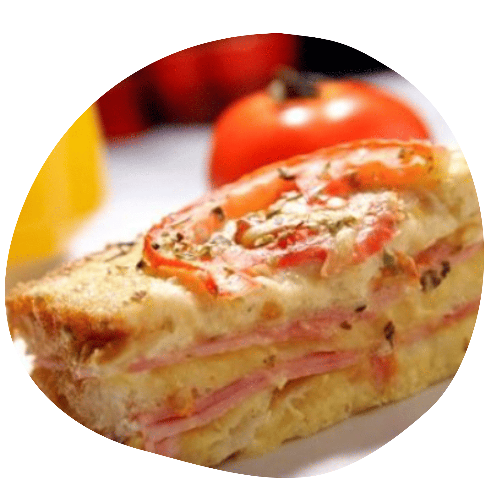 Close-up de sanduíche de pão de forma tostado com camadas de presunto, queijo e tomate, polvilhado com ervas. Fundo levemente desfocado.