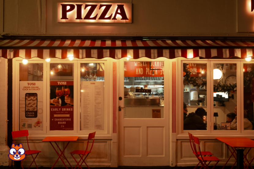 faixada branca e vermelha de uma pizzaria, com luzes quentes. 
