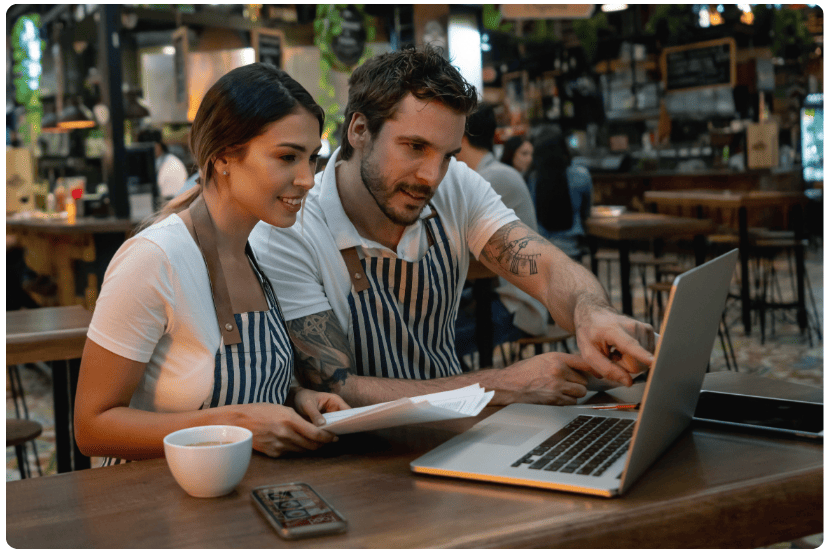 imagem de duas pessoas conferindo informações em um notebook