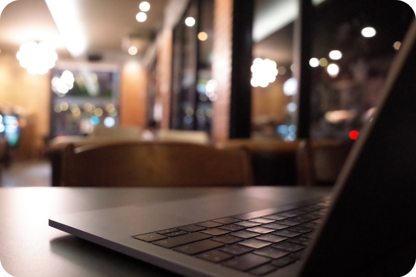 Notebook sobre mesa de madeira com fundo de restaurante desfocado